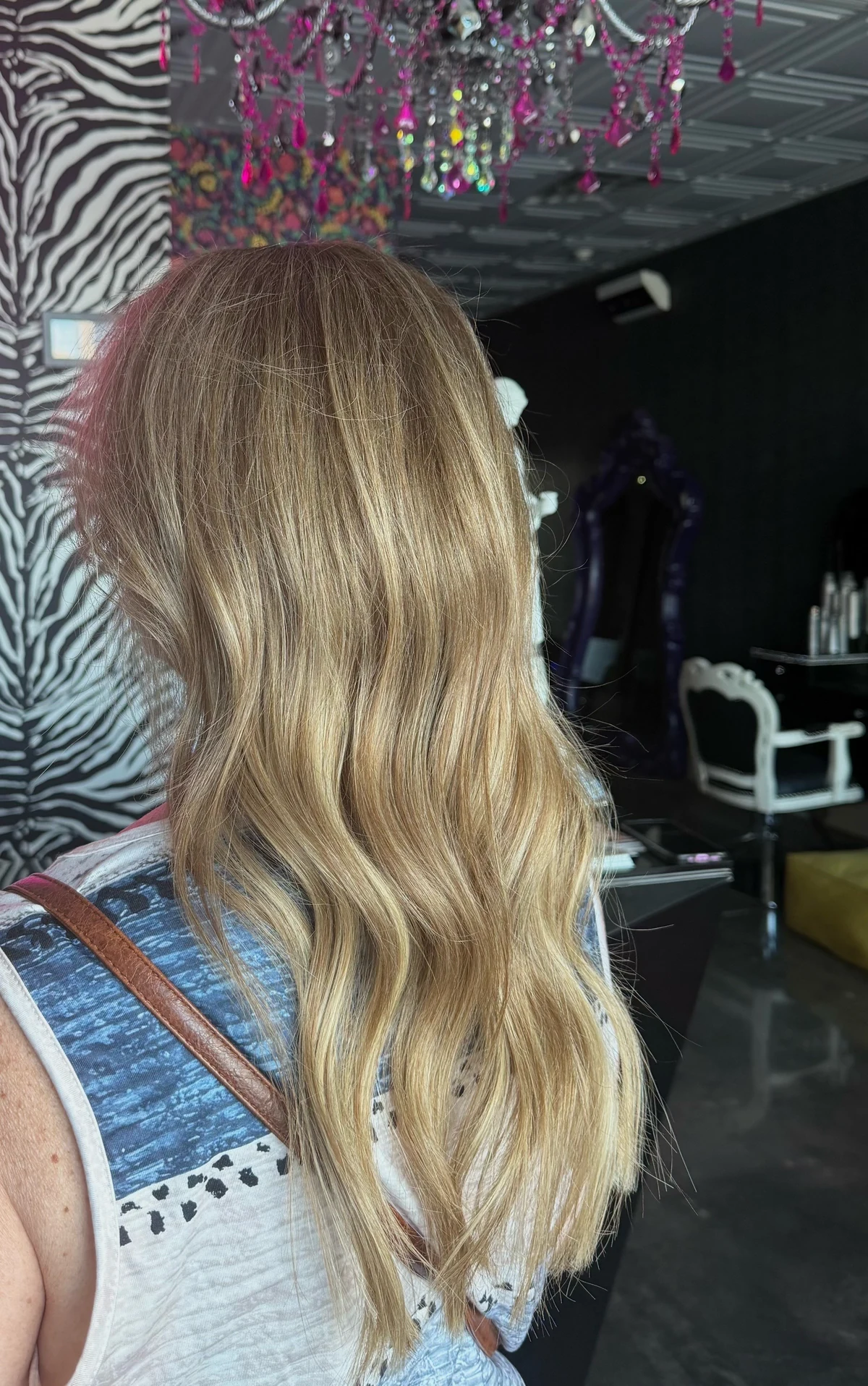 Long blonde hair extensions styled in loose waves
